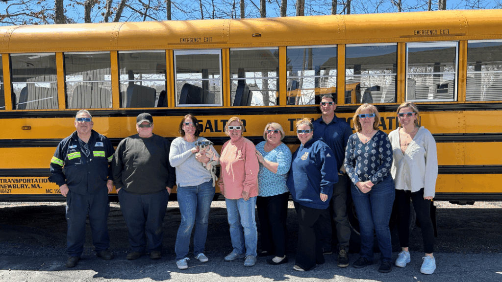 Corporate retreat transportation tips MA showing employees boarding a charter bus for a fall team event in Massachusetts